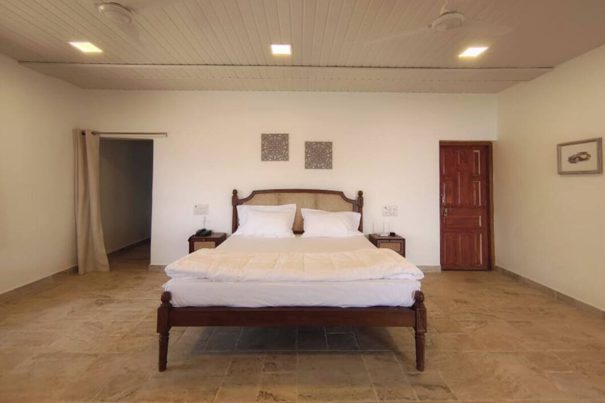 A bedroom with a wooden bed, a nightstand, a door, and a ceiling fan.