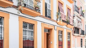 A row of terraced houses with balconies, wooden doors, and barred windows. - Beatiful design 1 bed apt D (Sevilla)