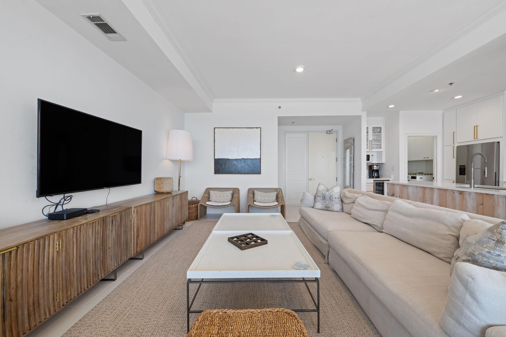 A modern living room with a flat-screen TV, a wooden console, a sofa, and a coffee table.