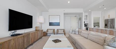 A modern living room with a flat-screen TV, a wooden console, a sofa, and a coffee table.