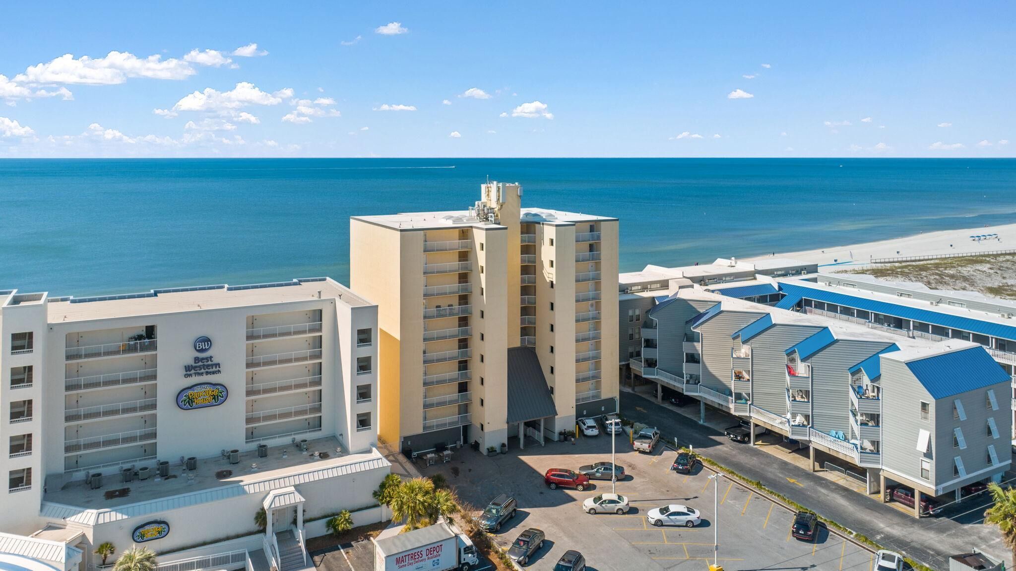 Un hotel con piscina, vista al mar y estacionamiento.