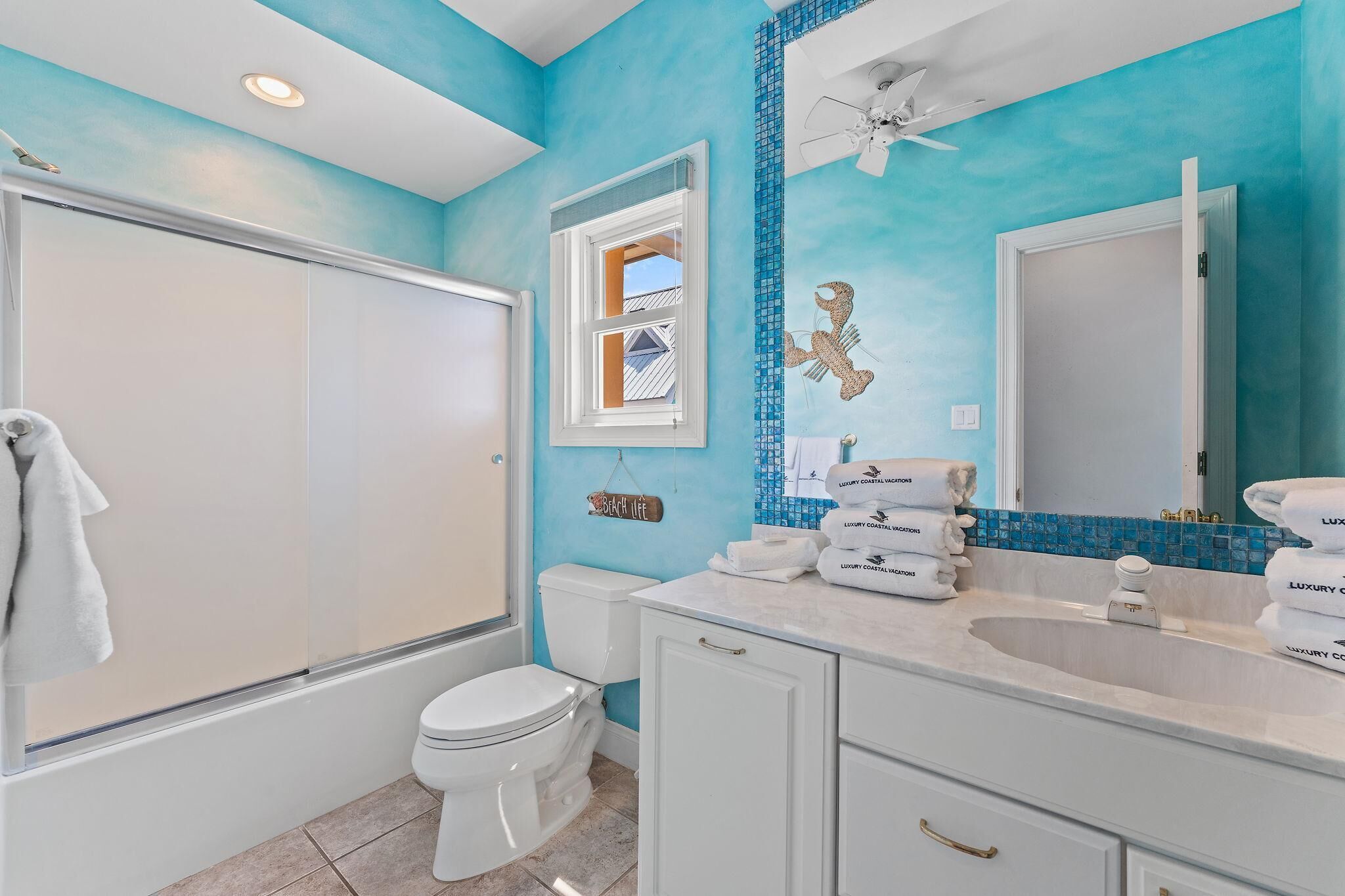 A bathroom with a shower, toilet, and sink.