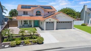 A two-story house with a garage, solar panels, and a well-maintained lawn.