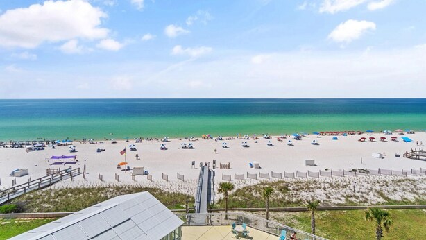 A beach with a walkway leading to the water, umbrellas, and beach chairs. - Perdido Sun 610 (Pensacola)