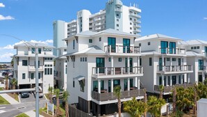 A modern multi-story hotel with balconies, large windows, and a parking area. - The Bluffs #6 - Coastal Bliss (Orange Beach)