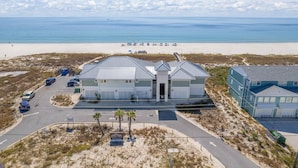 A beachfront property with a parking lot, a building with a garage, and a view of the beach and ocean. - Slow M'ocean at Lost Key Villas (Pensacola)
