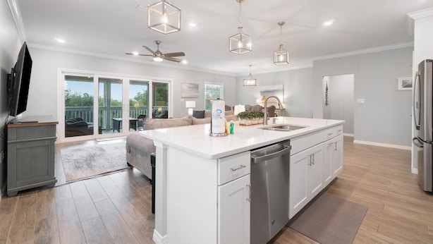 A modern kitchen with a central island, white cabinetry, stainless steel appliances, and pendant lighting. - Slow M'ocean at Lost Key Villas (Pensacola)