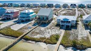 A coastal area with beach houses, a wooden boardwalk, and a clear view of the ocean. - Lime In The Coconut (Gulf Shores)