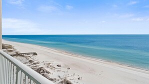 A beach view from a balcony with a wooden deck and sandy beach. - Regency Isle Penthouse 1106 (Orange Beach)