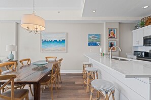 Enjoy meals in the kitchen with oven and dining area featuring a wooden table and chairs.