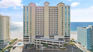 Un hotel de varios pisos con un atrium central, un estacionamiento subterráneo y vista a la playa.