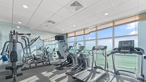 Un gimnasio con cintas de correr, elípticas y máquinas de pesas.