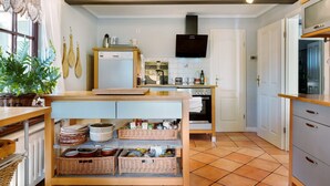 A kitchen with a wooden table, wicker baskets, a microwave, and a TV. - Holiday Home 'Elbparadies' with Private Terrace and Wi-Fi (Stade)