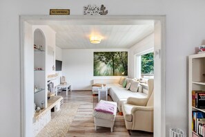 Una sala de estar acogedora con un sofá, una mesita de centro y una estantería.