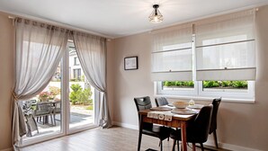 Un comedor con mesa, sillas y vistas amplias a través de grandes ventanales.