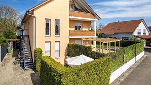 A two-story residential building with a balcony, a covered outdoor area, and a staircase leading to a garage. - Studio Apartment 'Ferienwohnung Lehen - Herr 1' with Shared Garden and Wi-Fi (Freiburg im Breisgau)