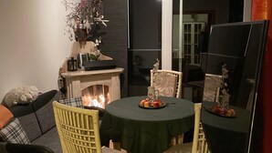An outdoor dining area with a round table, four chairs, a fireplace, and a large mirror reflecting the room. - Holiday Home 'Strandhuette Dc We 46' with Private Terrace, Private Garden and Wi-Fi (Graal- Müritz)