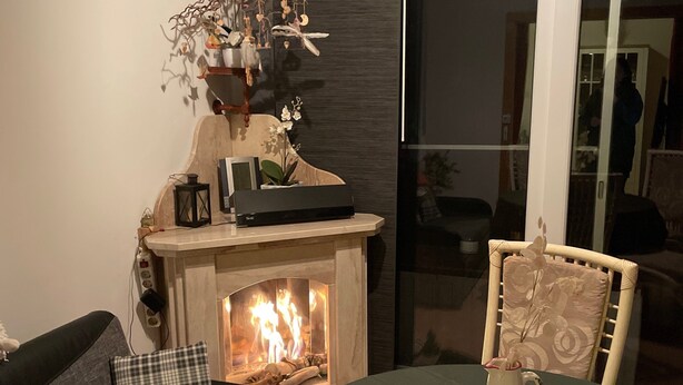 A living room with a fireplace, a sofa, a table with fruit, and a decorative wall piece. - Holiday Home 'Strandhuette Dc We 46' with Private Terrace, Private Garden and Wi-Fi (Graal- Müritz)