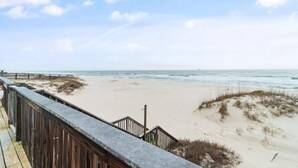 Une plage avec une promenade en bois et une rive sablonneuse.