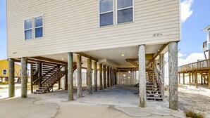 Un bâtiment à deux étages doté d’un espace extérieur couvert, soutenu par des piliers en bois.