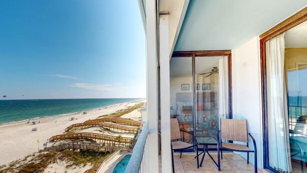 A balcony with a view of a beach and a pool. - Summerchase 506 (Orange Beach)