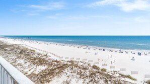 A beach with a wooden boardwalk leading to the water, sandy beach, and a clear sky. - Summerchase 506 (Orange Beach)