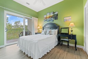 Une chambre à coucher comprenant un lit, une table de chevet, une commode et une vue sur l’extérieur.