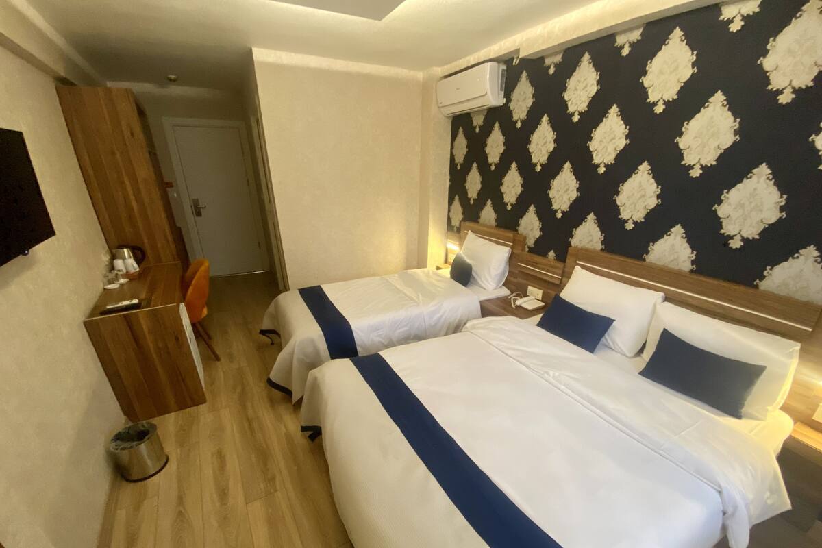 Une chambre d’hôtel avec deux lits, un bureau et une chaise.