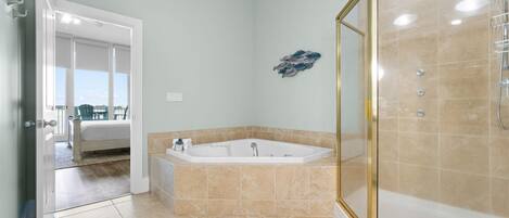 A bathroom with a bathtub, shower, and a glass-enclosed shower area.