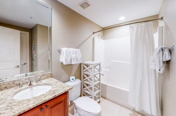 Une salle de bain avec deux lavabos, des toilettes, une douche et un miroir.