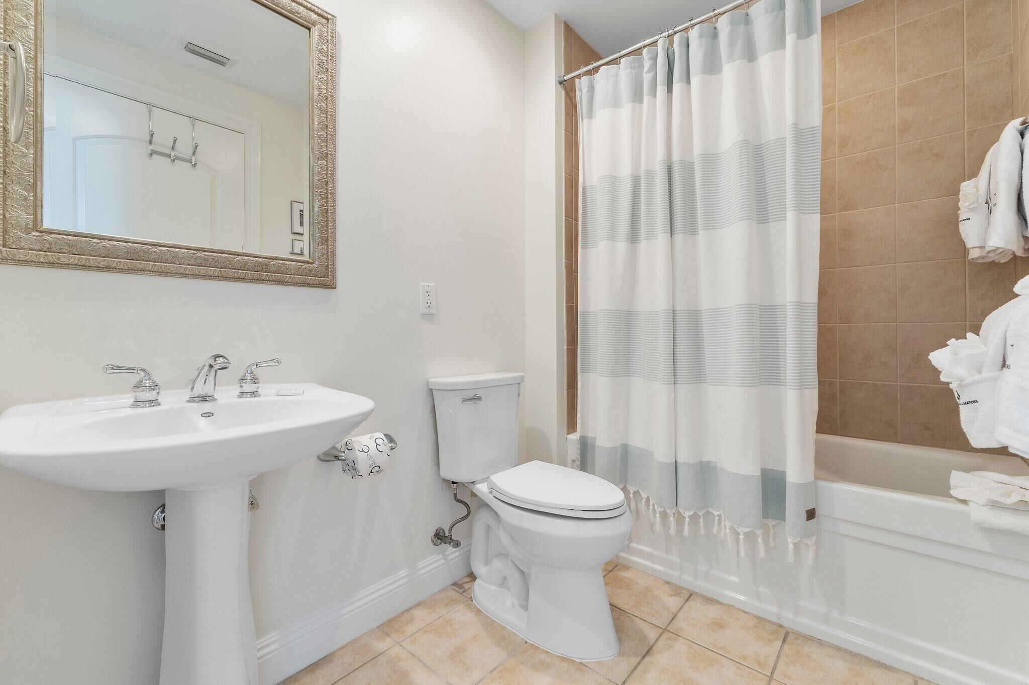 A bathroom with a white sink, toilet, and bathtub.
