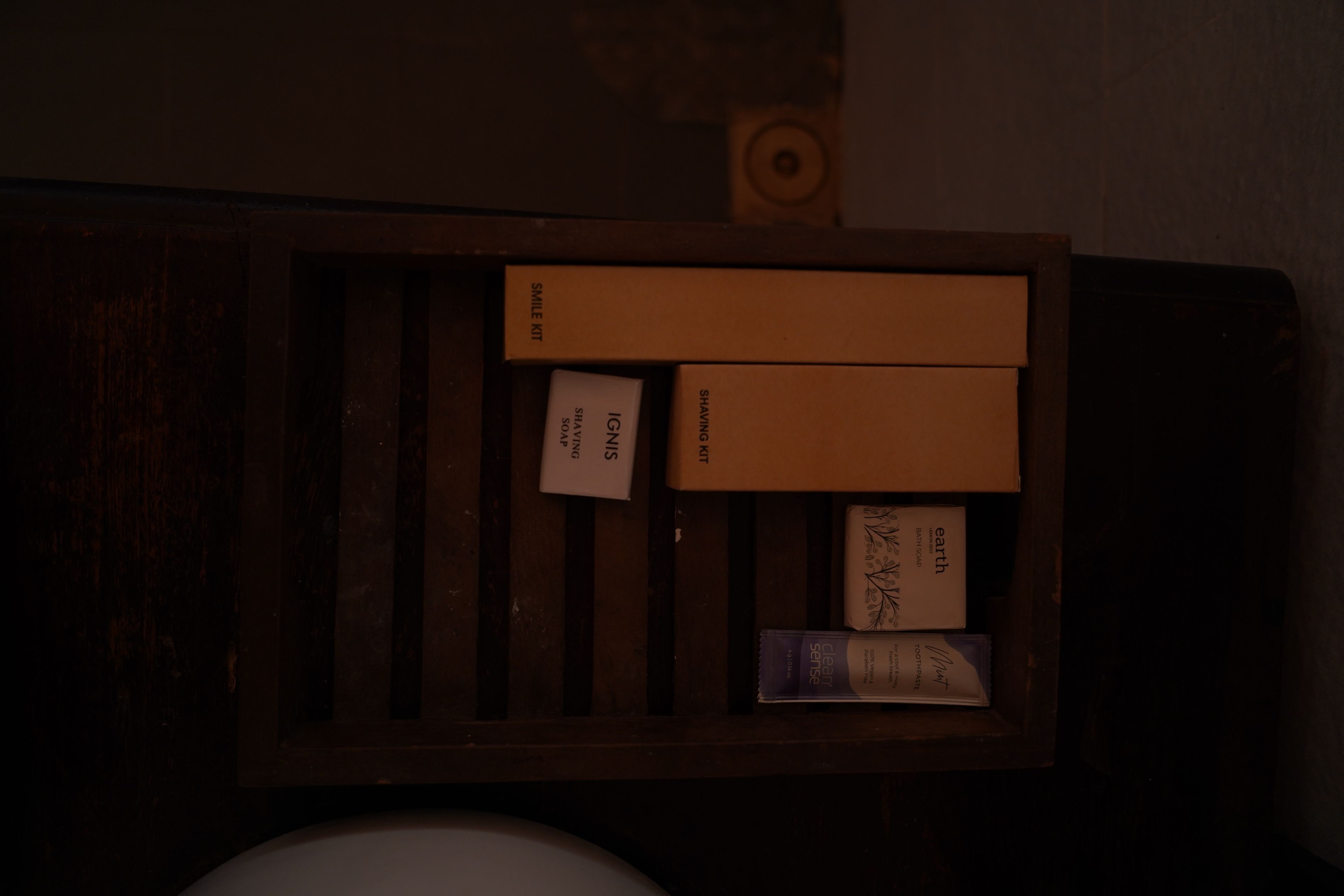 A wooden box containing various toiletries including a shaving kit, soap, and a toothbrush.