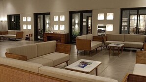 Un vestíbulo amplio con varias zonas de estar, incluyendo sofás y sillones, y una mesa de centro.