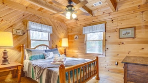 A wooden cabin bedroom with a bed, nightstands, a wooden dresser, and a ceiling fan. - Quaint Dahlonega Cabin w/ Cavenders Creek Access! (Dahlonega)