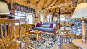 A wooden interior with a sofa, chairs, a table, and a patterned rug. - Quaint Dahlonega Cabin w/ Cavenders Creek Access! (Dahlonega)