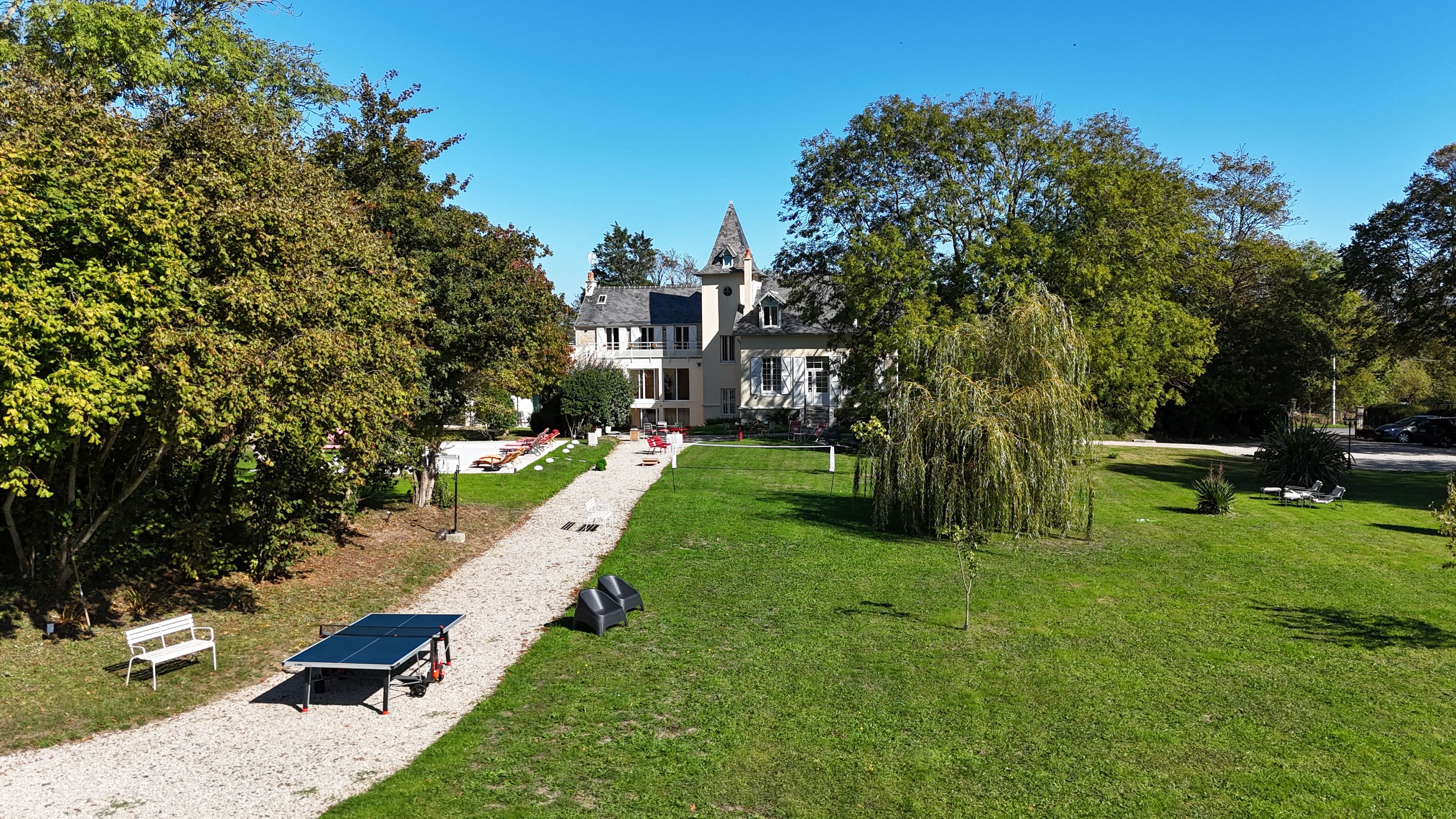 A large building with a prominent tower, surrounded by a well-maintained lawn and trees.