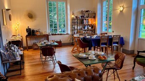 A cozy dining area with a wooden table set for a meal, surrounded by chairs. - LA VILLA MIRABELLE (Tracy-sur-Mer)