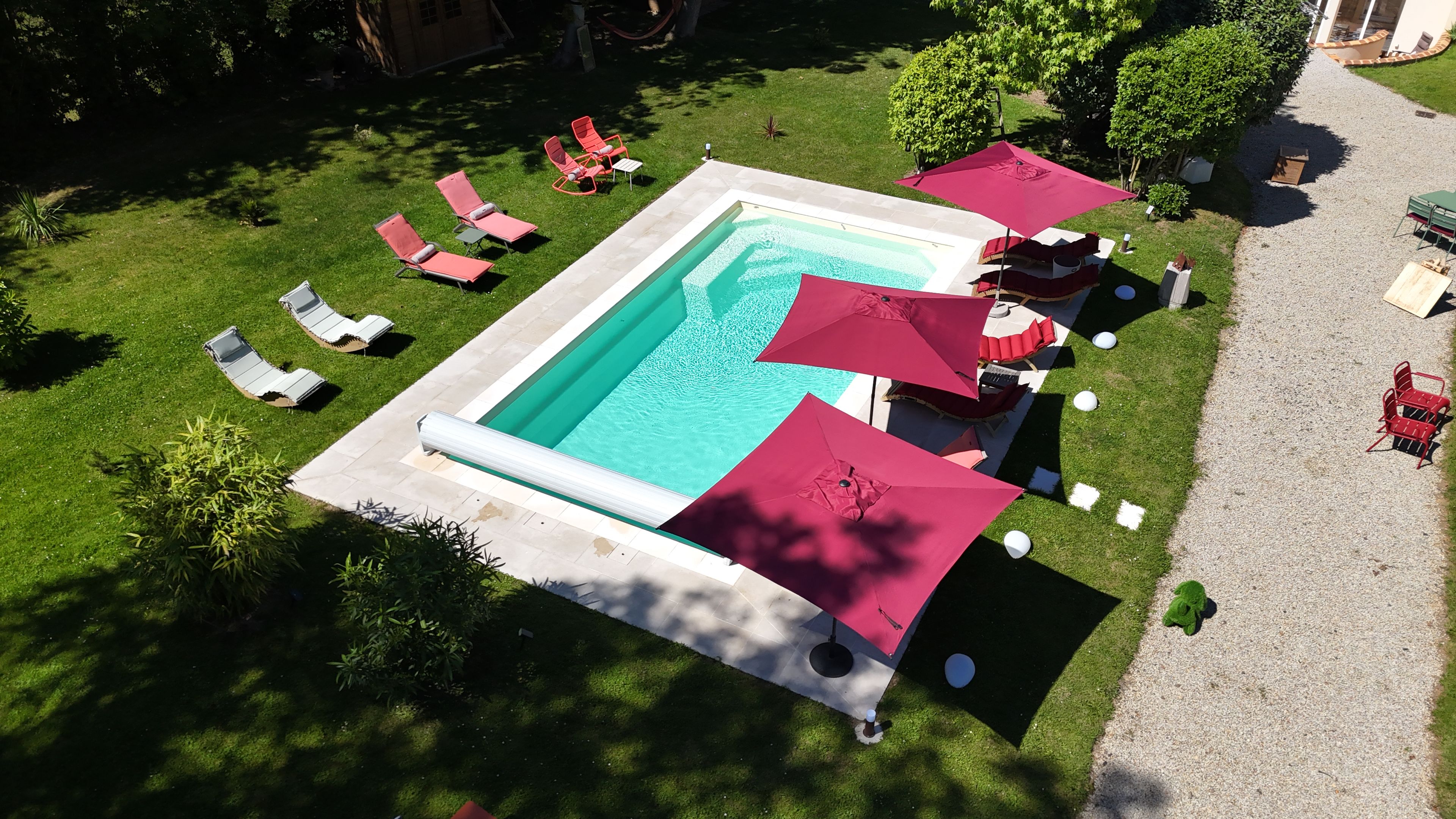 An aerial view of a pool area with multiple sun loungers and umbrellas.