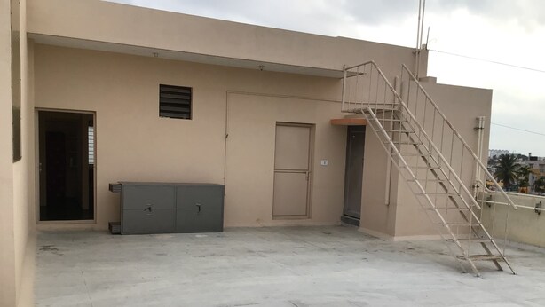 Ein Gebäude mit Treppe, Tür und einem Metallschrank.