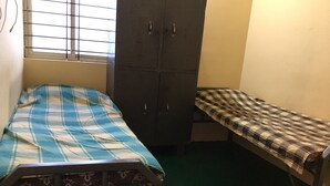 Ein kleines Zimmer mit einem Bett, einer Bank und einem Kleiderschrank.