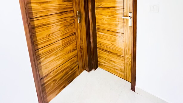 A corner room with wooden wardrobes and a white floor. - Roomshala 160 Hotel Red (New Delhi)