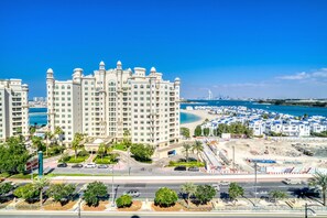 Ein Hochhaus-Hotel mit zahlreichen Balkonen, einer Strandlage und einer Marina mit Booten.