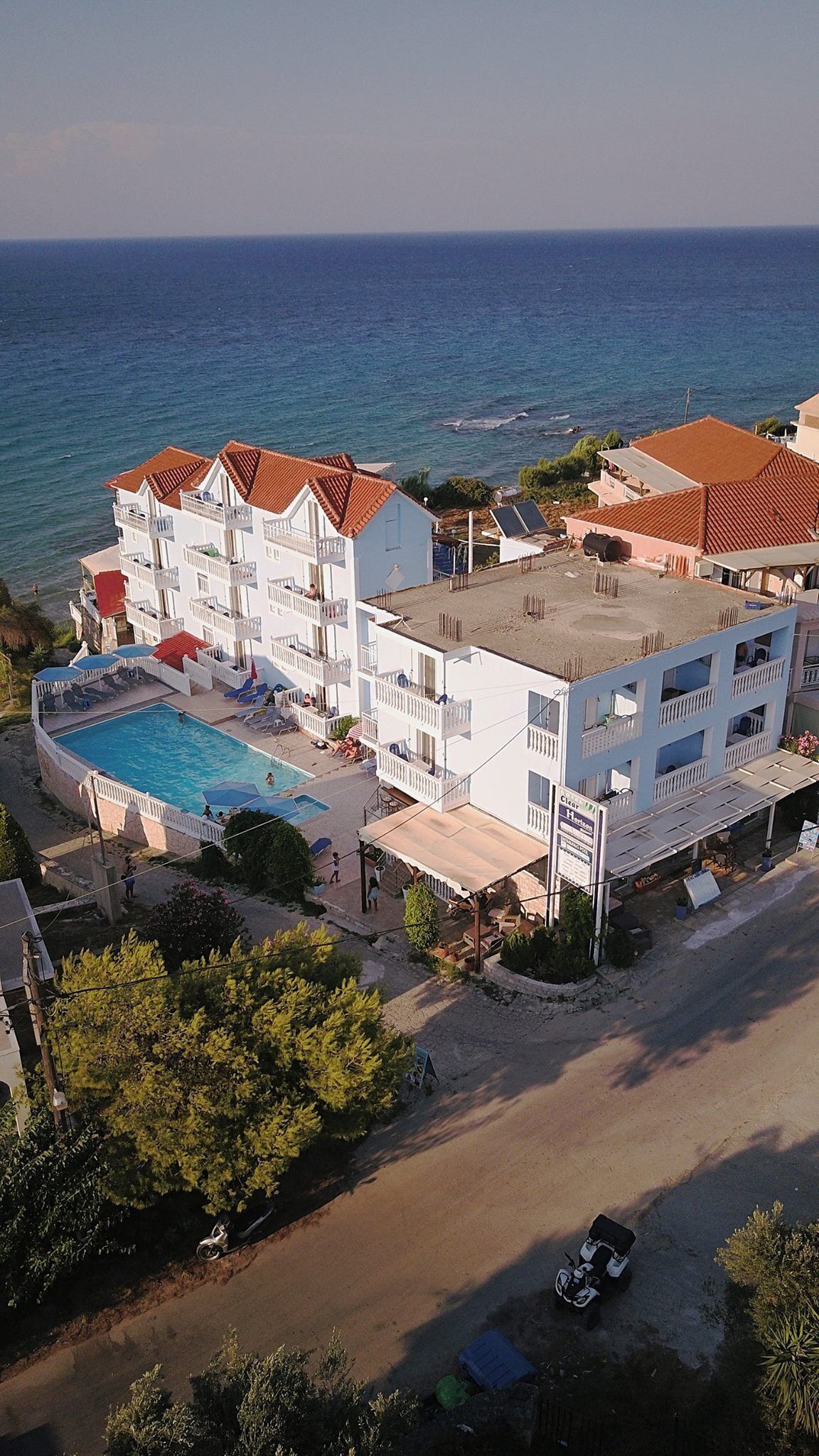 Un hôtel doté d’une piscine, de plusieurs balcons et offrant une vue sur la mer.