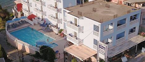 Un hôtel doté d’une piscine, de plusieurs balcons et offrant une vue sur la mer.