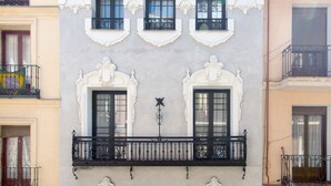 Un bâtiment doté de nombreux balcons, de cadres de fenêtres richement décorés et d’un élément décoratif central.