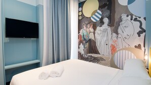 A hotel room with a bed, a flat-screen TV mounted on the wall, a mural with abstract art, and a nightstand with a lamp. - Design Apartment in Barrio de las Letras A1I (Madrid)