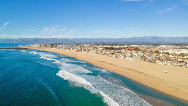 An aerial view of a coastal town with a beach, clear blue waters, and distant mountains. - Silver Surf Bungalow w/ Hot Tub - Steps from Beach (Oxnard)