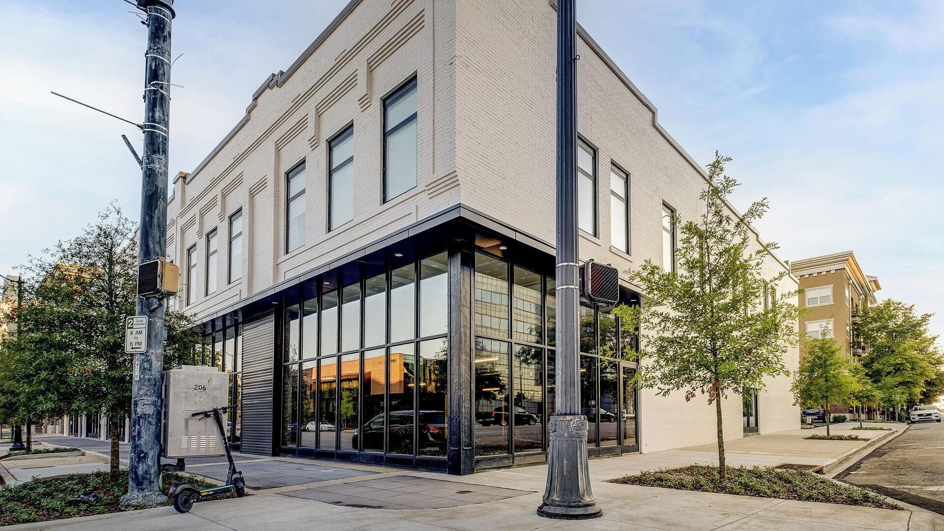 A corner building with large windows, a loading dock, and a parking area.