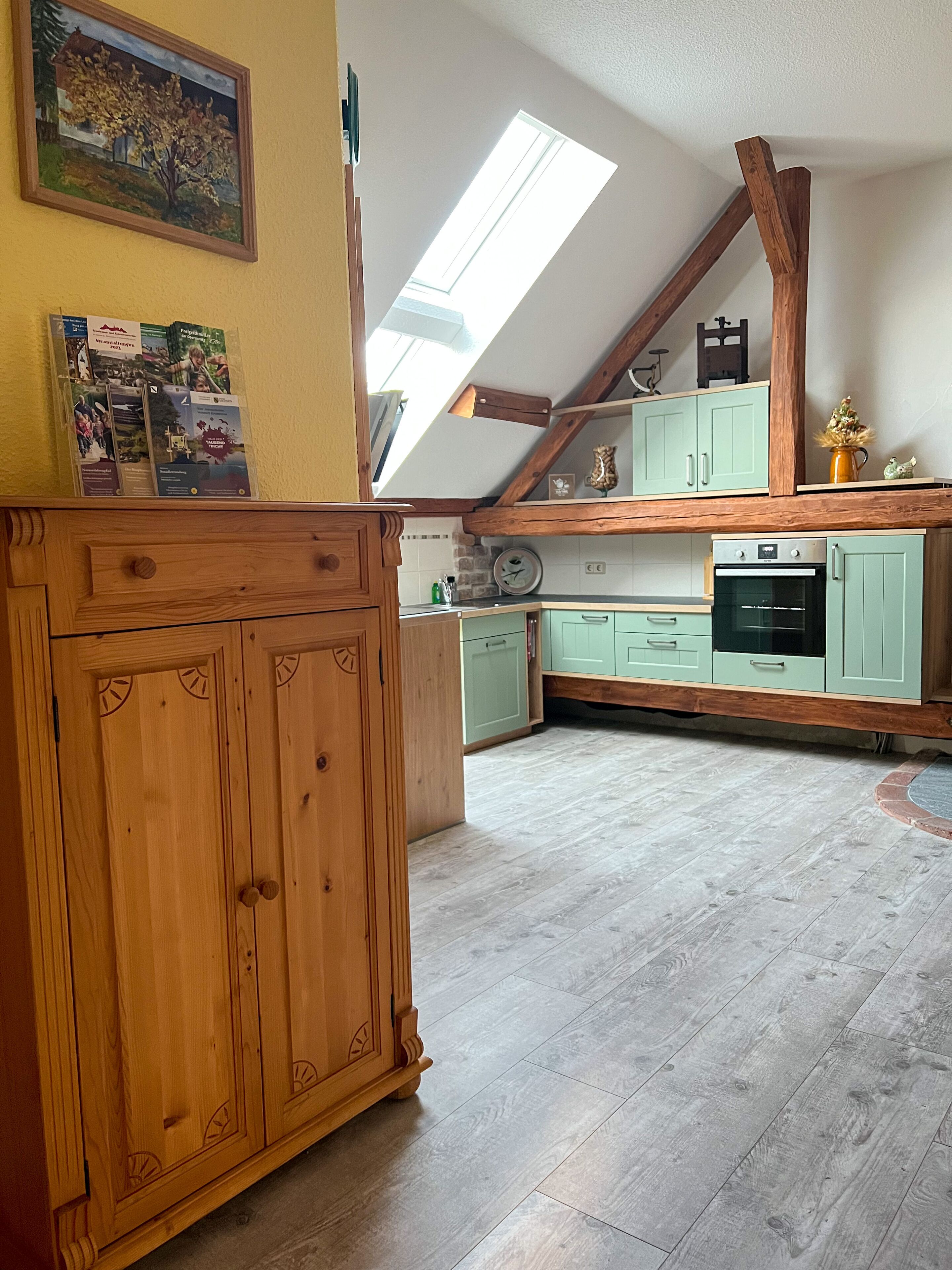 A kitchen with wooden cabinets, a clock, and a window.