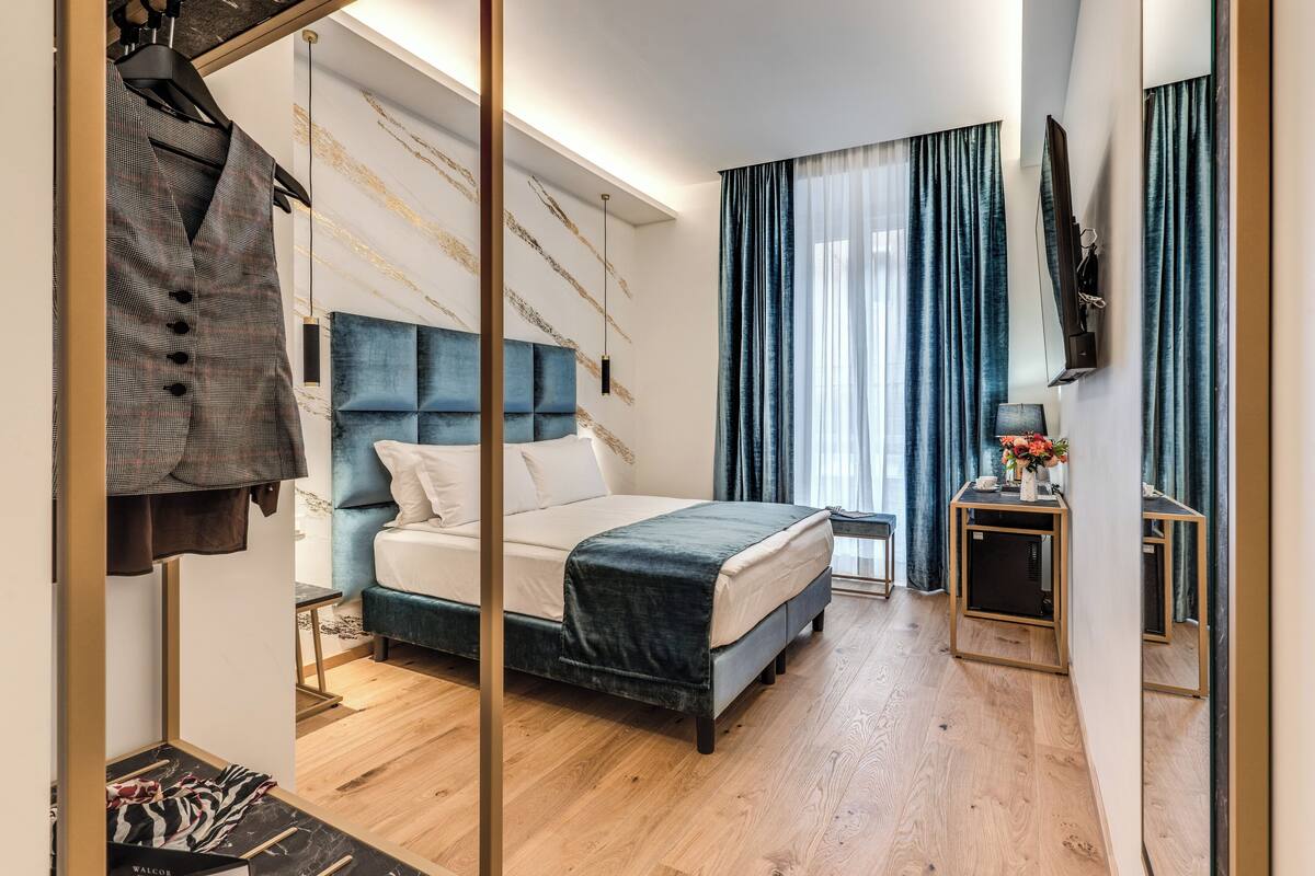 Een moderne slaapkamer met een bed, een kaptafel en een kapstok.